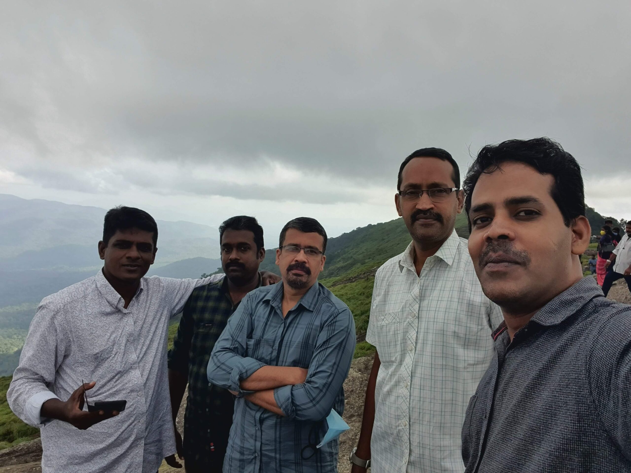 View of Ponmudi hills covered in mist, with clouds floating close to the ground