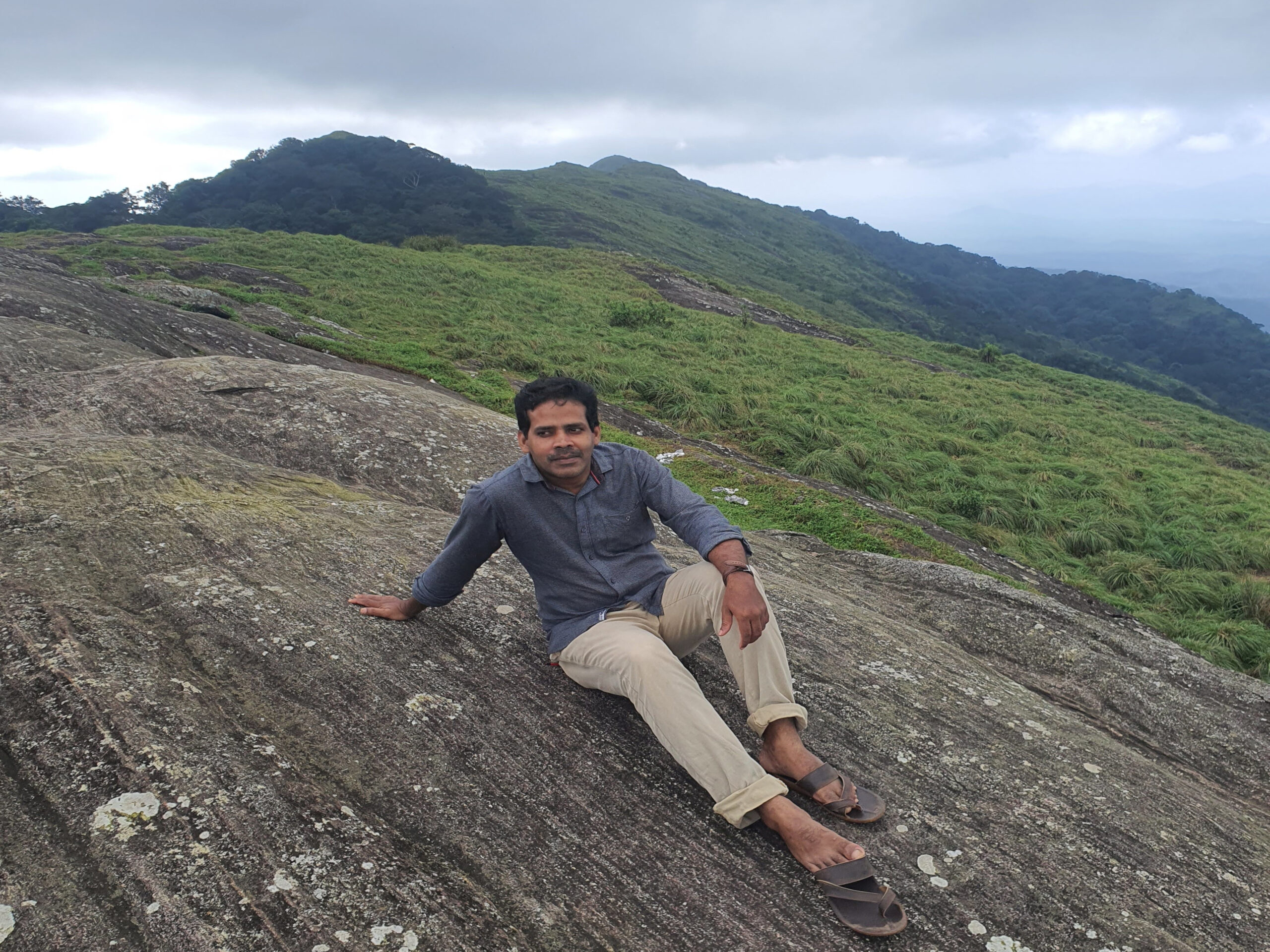 Sunset view from Ponmudi hills with orange sky and hills in silhouette